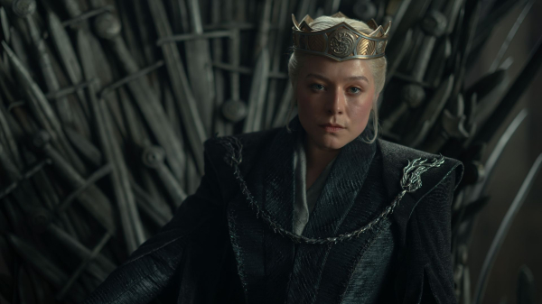 Emma D'Arcy as Rhaenyra Targaryen in a still from House of the Dragon season three sitting on the throne with a crown.